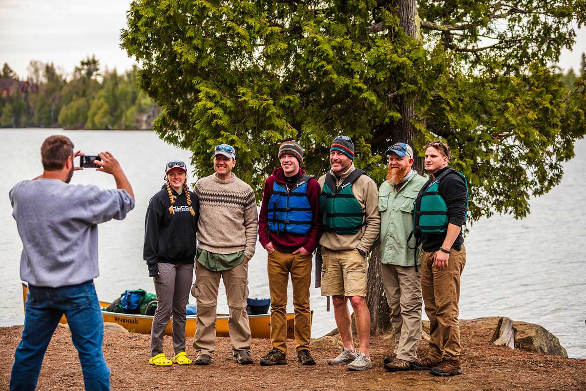 Beginners in the BWCAW with veterans getting a photo by an Outfitter