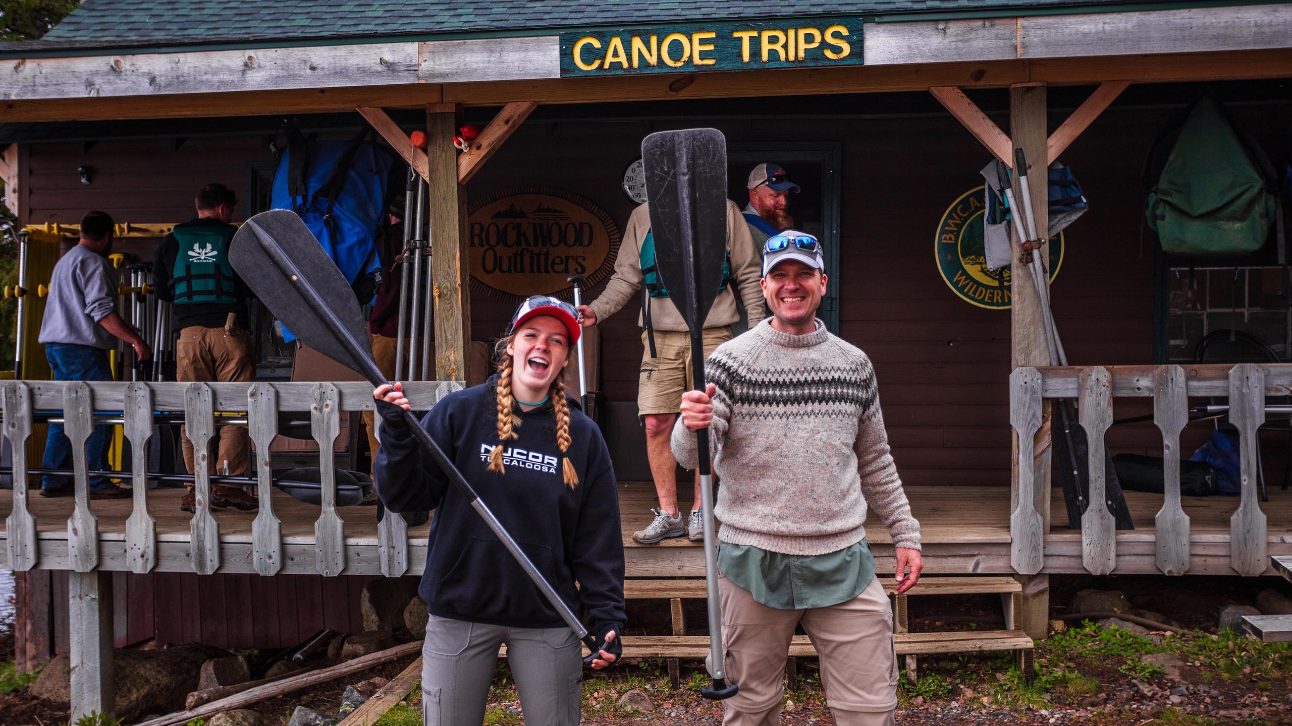 outfitting canoe paddles two people smiling holding paddles